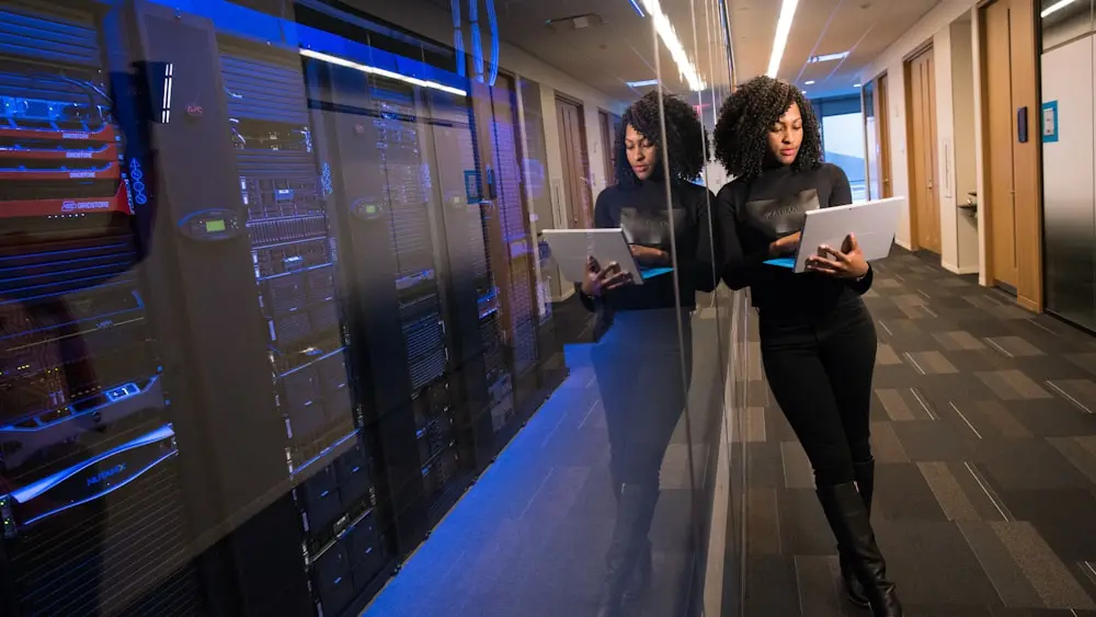 Two engineers walking a lit aisle between server racks