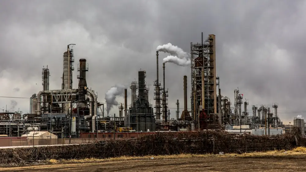 A refinery at dusk, columns and stacks against a grey sky