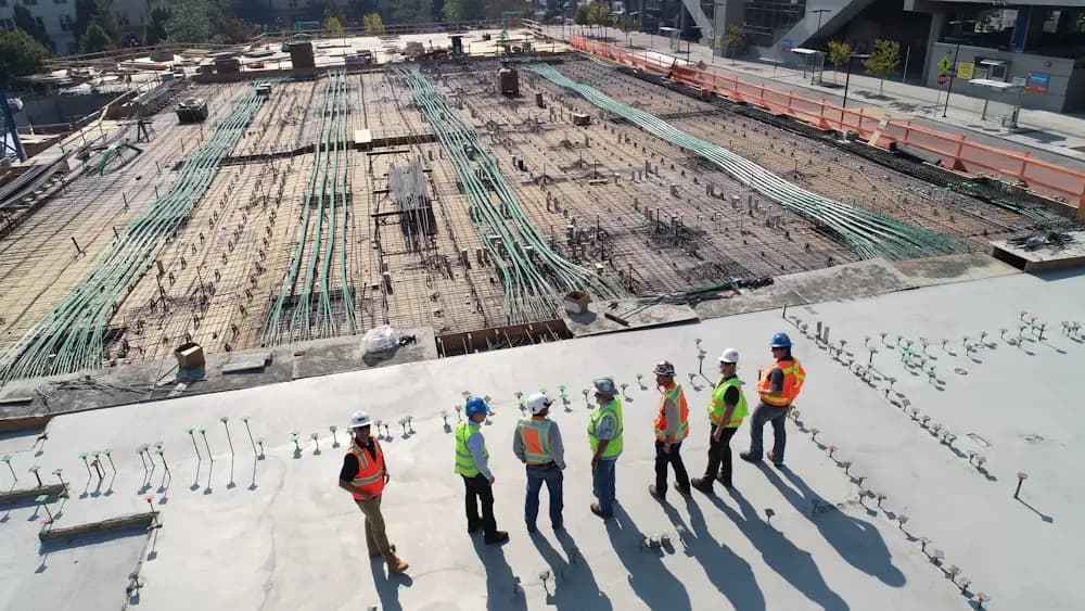 A construction site seen from above, crews spread across the deck