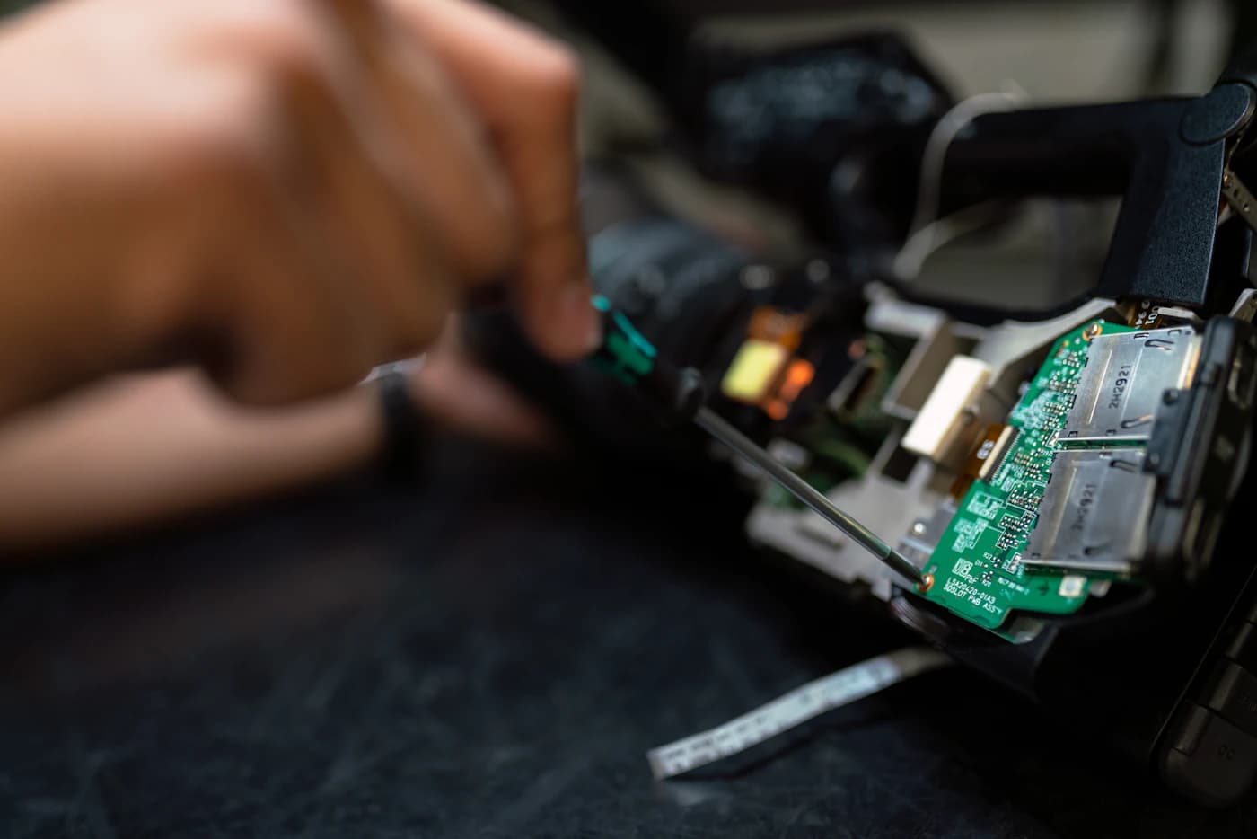 Close hands-on work on a circuit board with a screwdriver