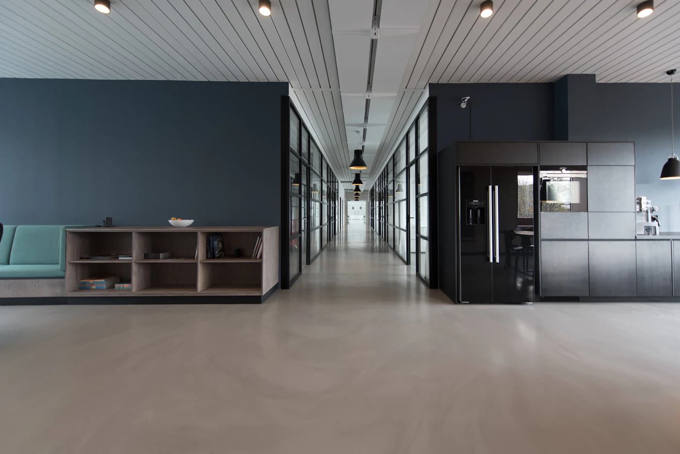 Long, quiet corridor through a modern office building