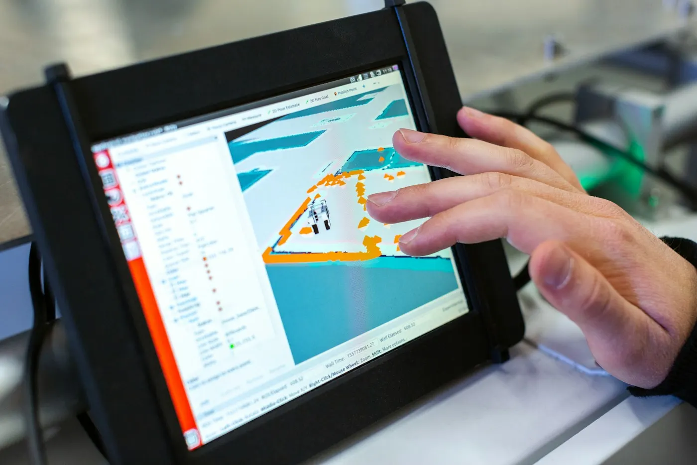 An engineer's hand working a simulation model on a touchscreen display